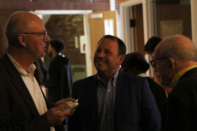 a group of men smiling and talking