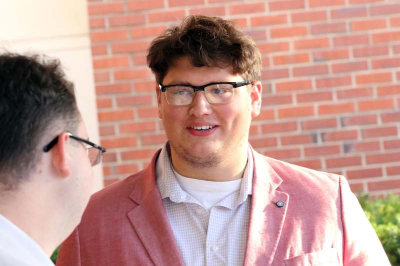 a man in glasses smiling