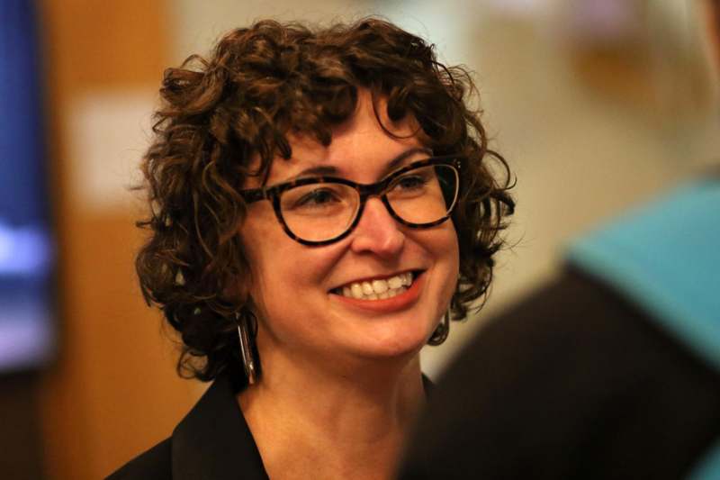 a woman with curly hair wearing glasses