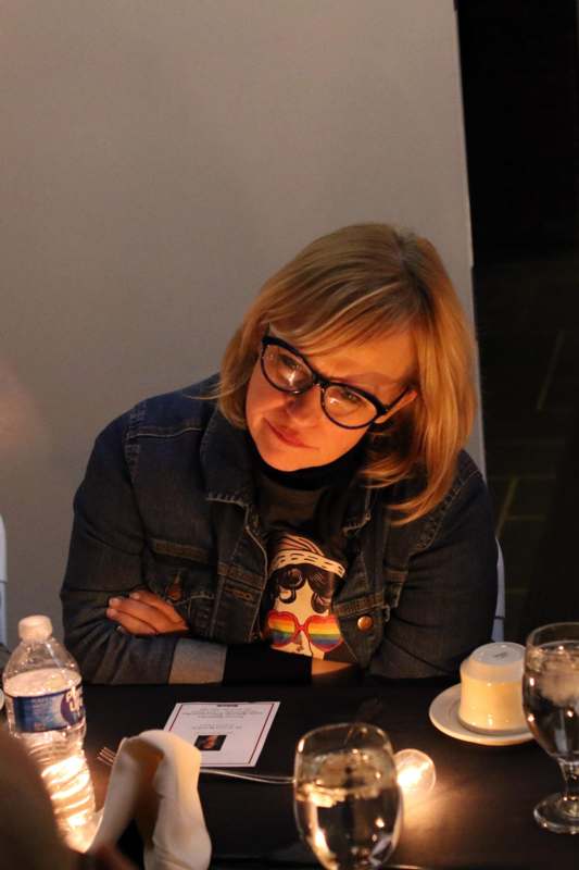 a woman sitting at a table with her arms crossed