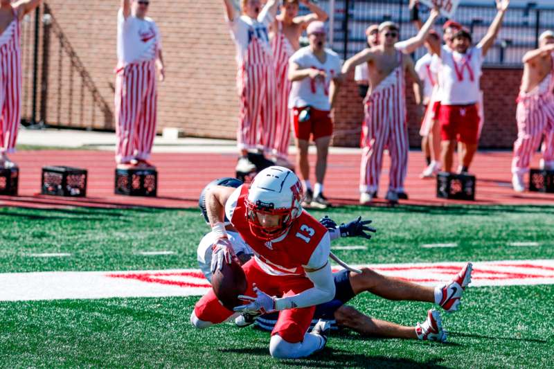 a football player falling down to catch a football