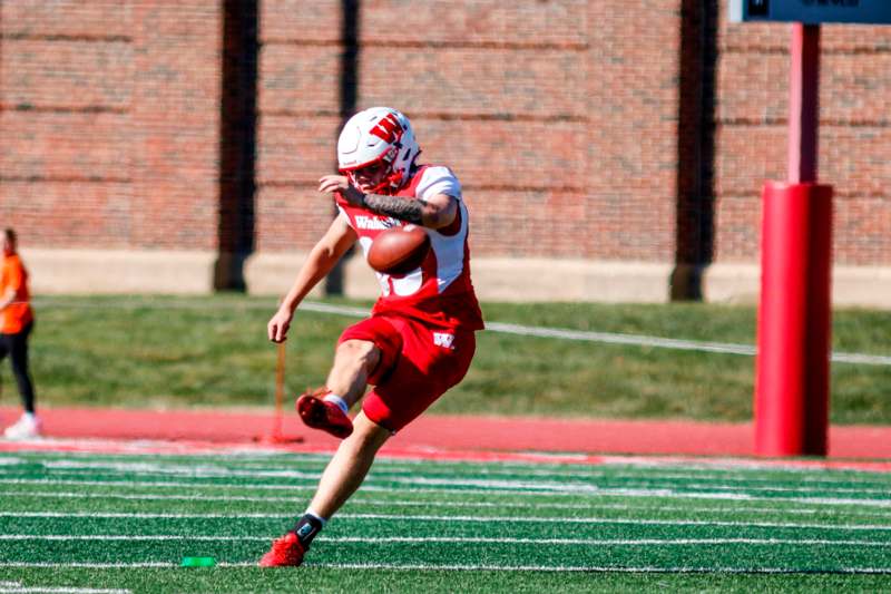 a man in a football uniform running with a football