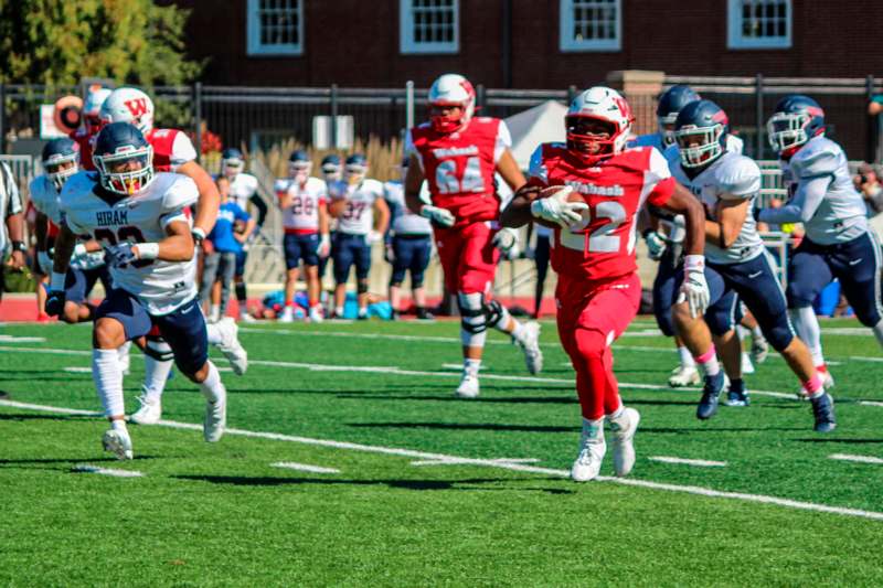 a group of football players running on a field