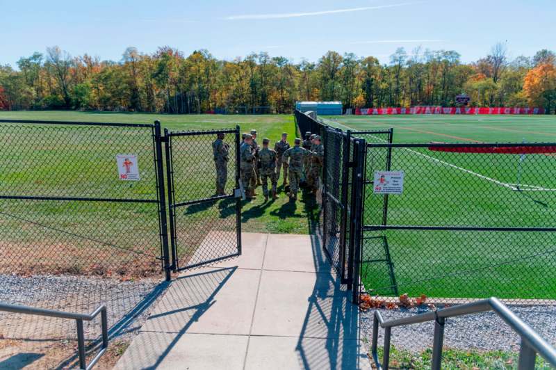 a group of people standing in front of a fence