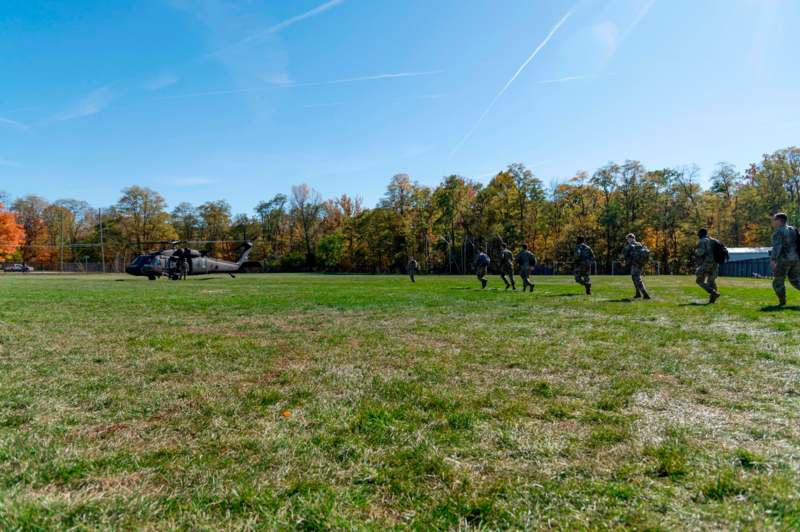 a group of soldiers running on a grass field