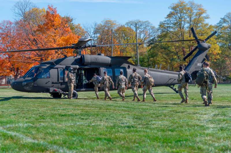 a group of people walking by a helicopter