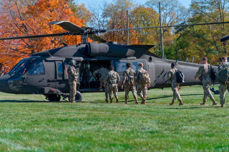 a group of soldiers walking out of a helicopter