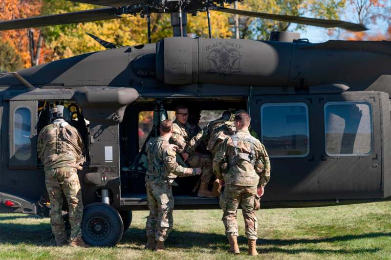 a group of people in military uniforms getting out of a helicopter