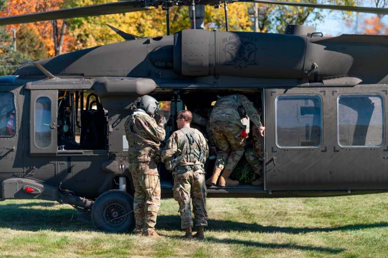 a group of people in uniform getting out of a helicopter