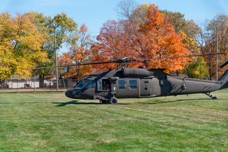 a helicopter on grass with trees in the background