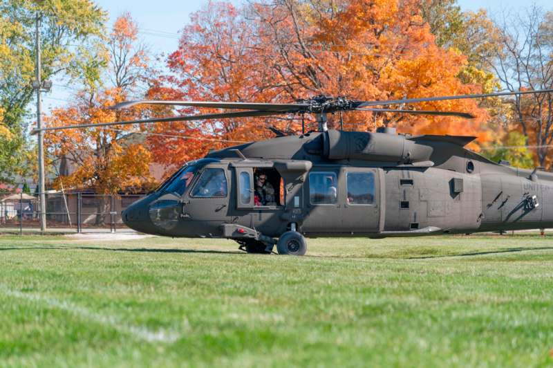 a helicopter on grass with trees in the background