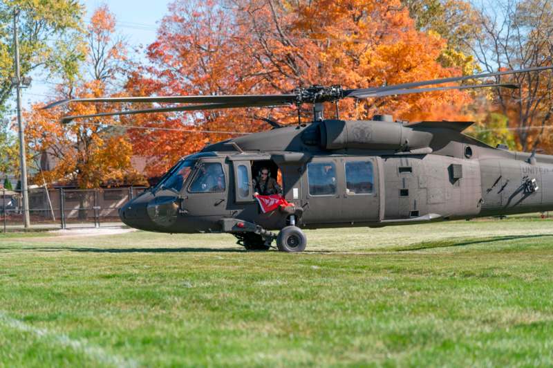 a helicopter on grass with a person sitting in the back