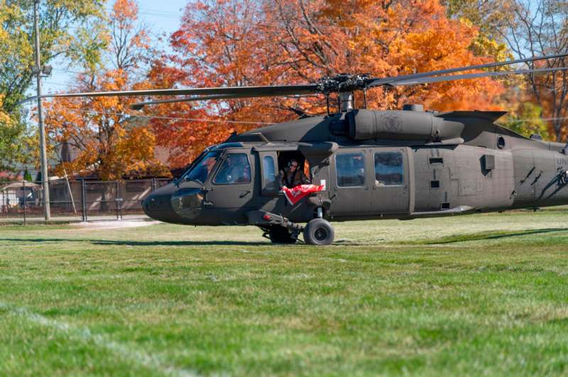 a helicopter on grass with trees in the background