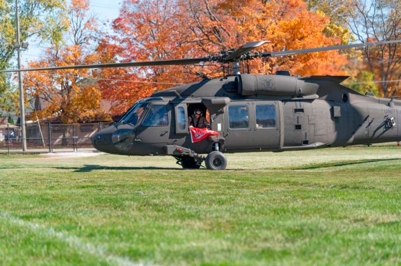 a helicopter on grass with a person in the back