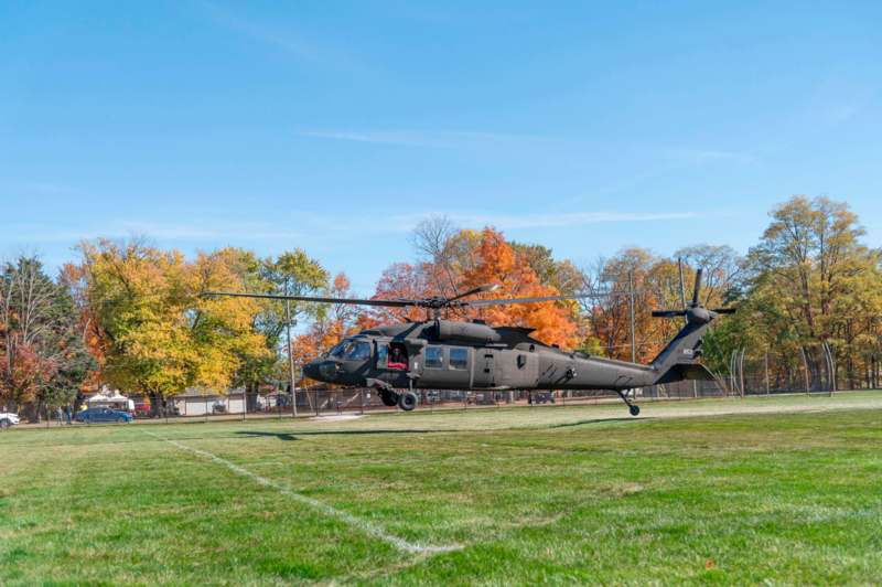 a helicopter flying on a grass field