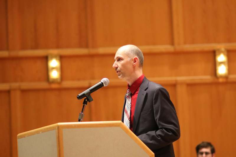 a man standing at a podium with a microphone