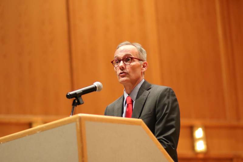 a man standing at a podium with a microphone