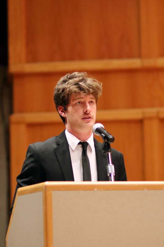 a man standing at a podium with a microphone