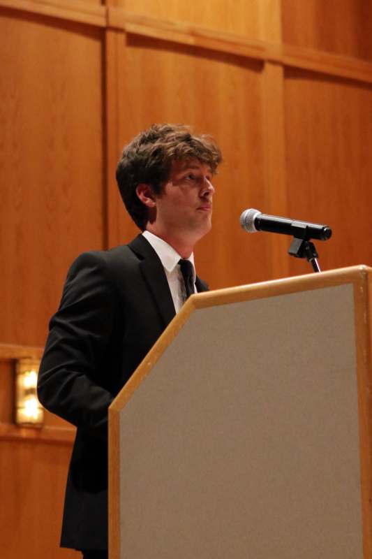 a man standing at a podium with a microphone