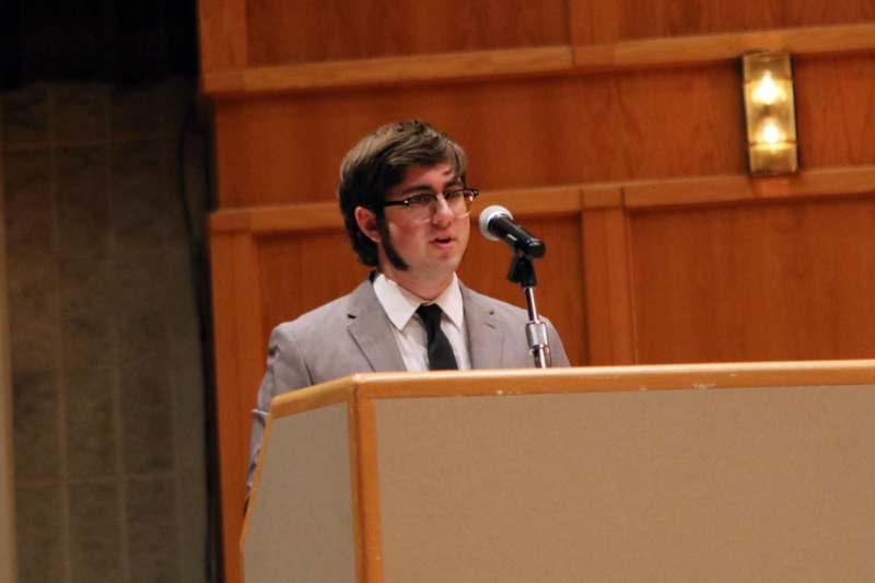 a man standing at a podium speaking into a microphone