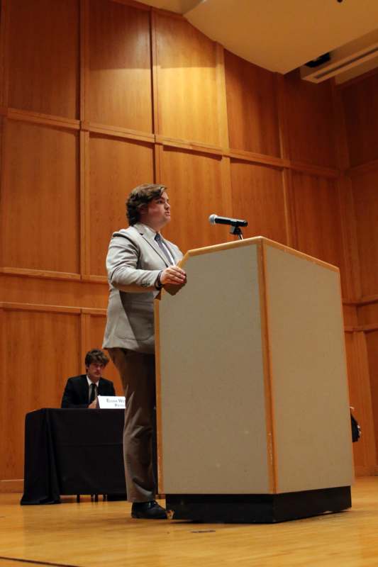 a man standing at a podium with a microphone