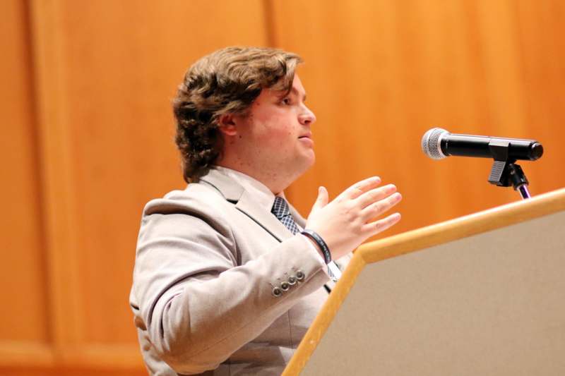 a man standing at a podium with his hands raised