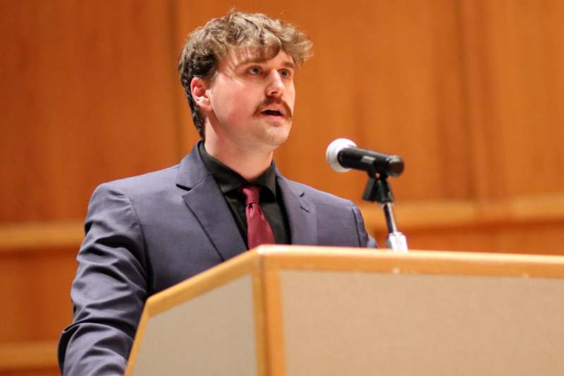 a man standing at a podium with a microphone