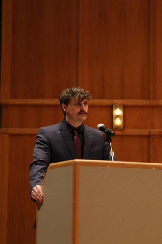 a man standing at a podium with a microphone