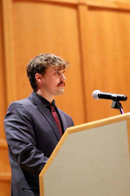 a man standing at a podium with a microphone