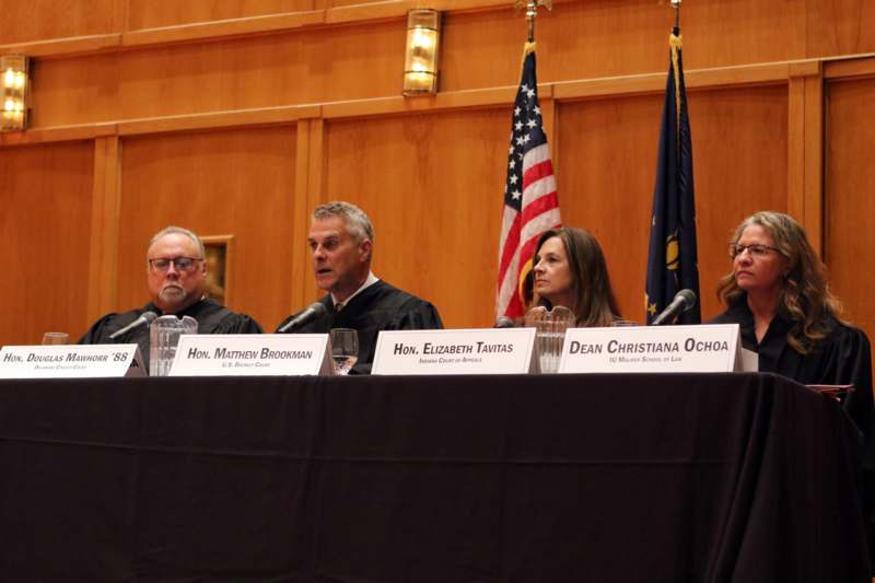 a group of people sitting at a table with microphones