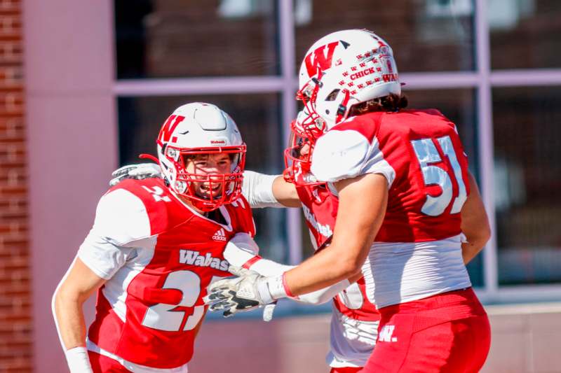 a group of football players in red and white uniforms