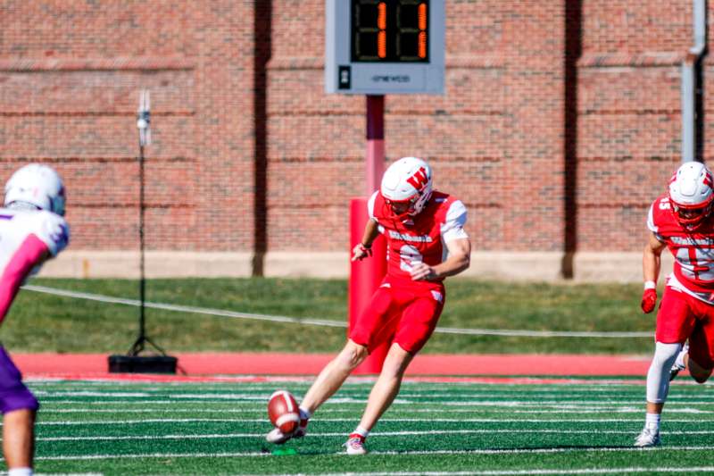 a football player in a red uniform running with a football