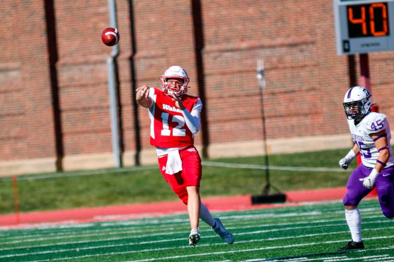 a football player in a red uniform catching a football