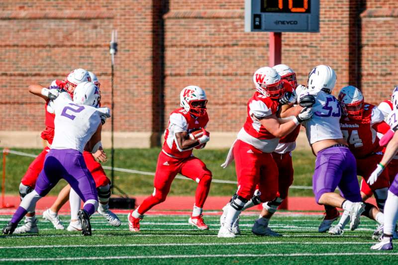 a group of football players running on a field