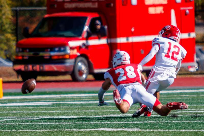 a football player falling down to catch a football