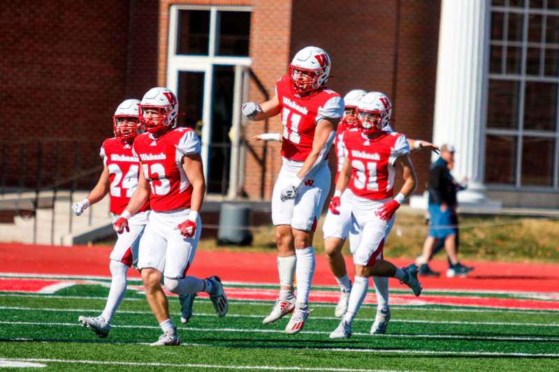 a group of football players running on a field