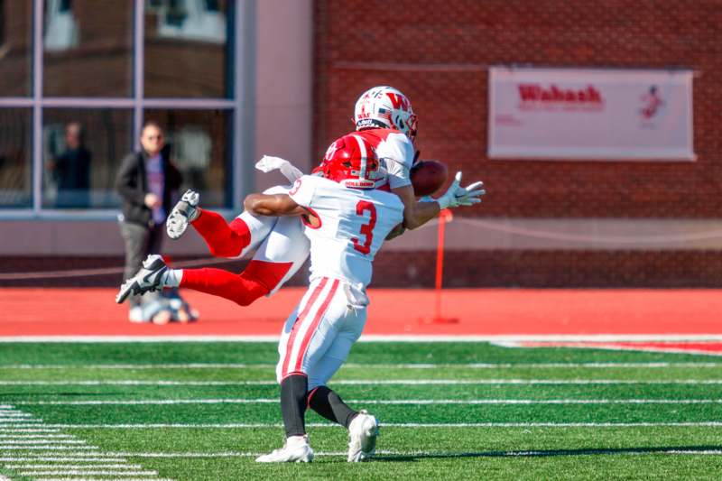 a football player in a red uniform with a football in the air