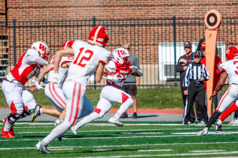 a football player running with a football in the air