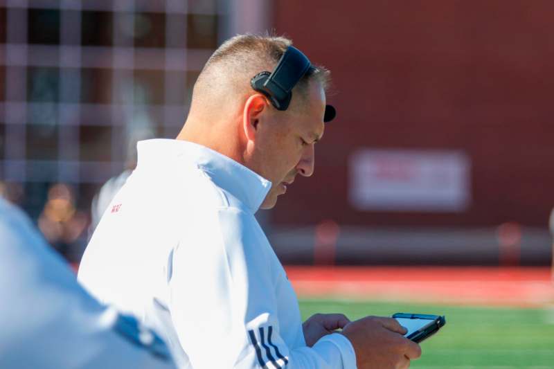 a man wearing headphones looking at his phone