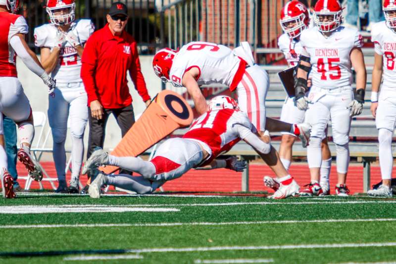 a football player falling over a player on the field