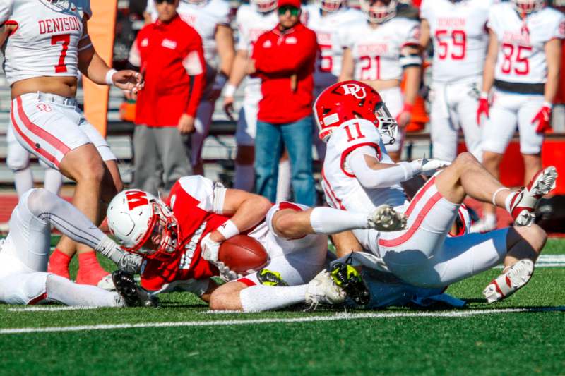 a football player falling down while another player is falling