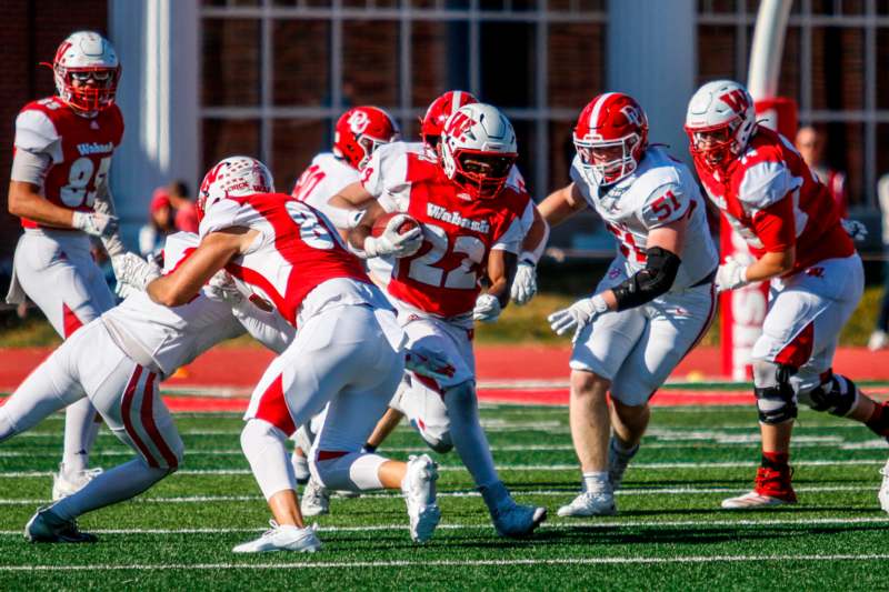 a group of football players running on a field