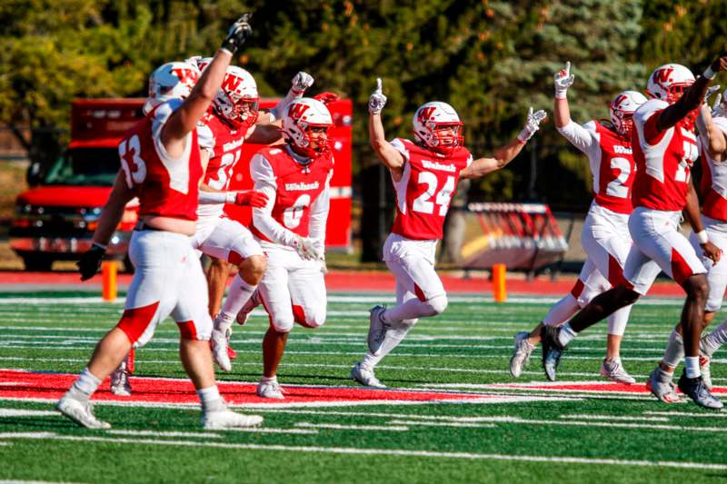 a group of football players running on a field