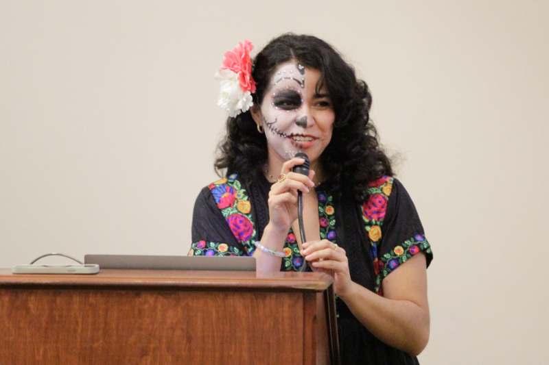 a woman with face paint holding a microphone