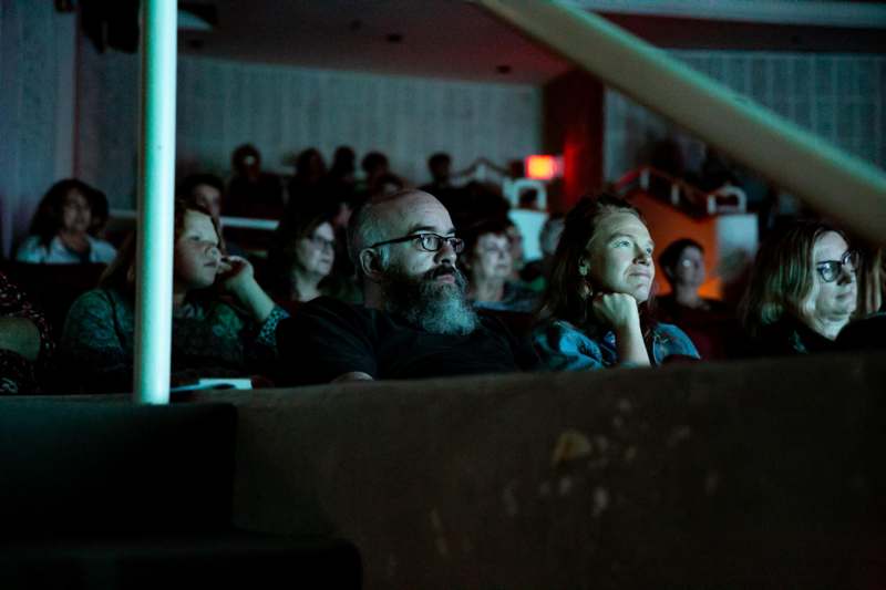 a man and woman sitting in a theater