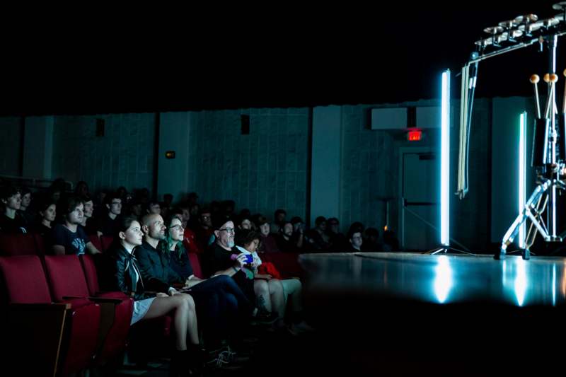 a group of people sitting in a room with a screen