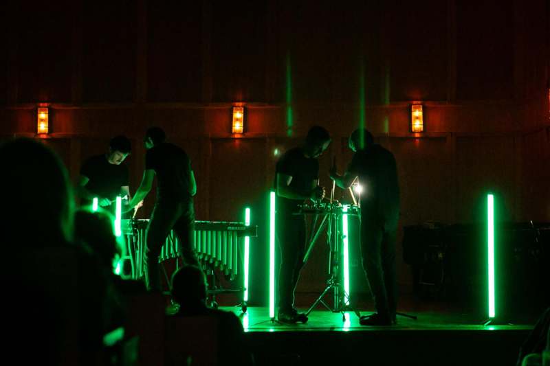 a group of men on a stage with green lights