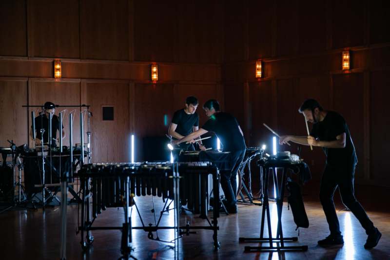 a group of men playing instruments in a dark room