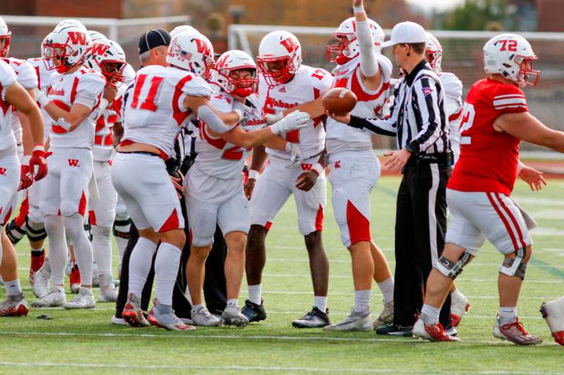 a group of football players huddle on a field