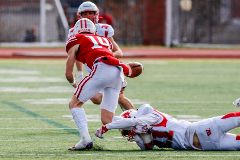 a football player falling down to catch a football